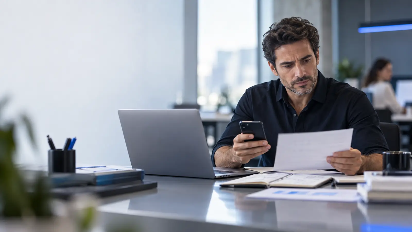 Empresário preocupado olhando o celular e um relatório
